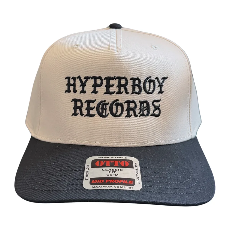 Hyperboy Records hat with a cream crown, black brim, and embroidered blackletter logo